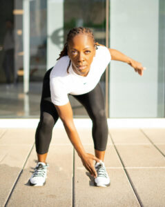 Coach Niki Wilburn, Registered Nurse and Certified Personal Trainer, in an active pose for the Fitness That Refuels Her workshop.